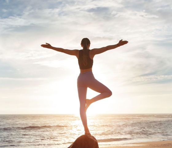 Woman Doing Yoga On Rock