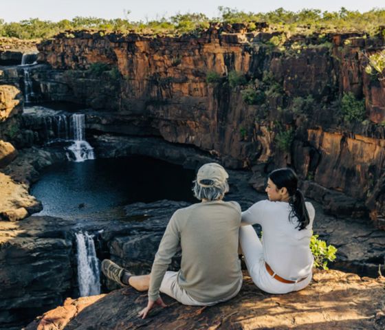 People sitting out looking at waterfall