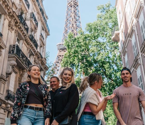 Friends laughing on the streets of Paris with Eiffel Tower in the background