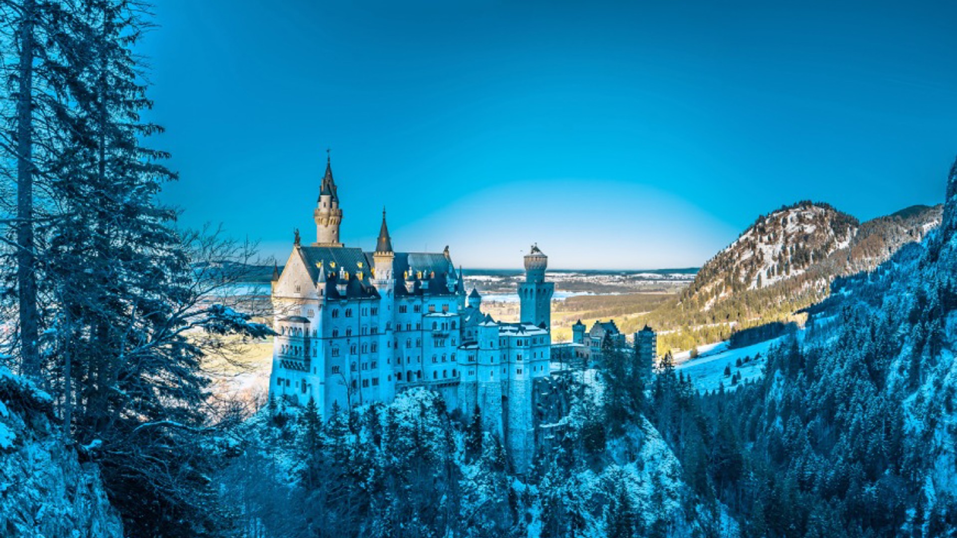Castle nestled in snowy mountain peaks - Credit: Unsplash / Bharat Patil