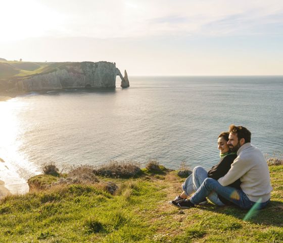 People sitting overlooking view of Normandy