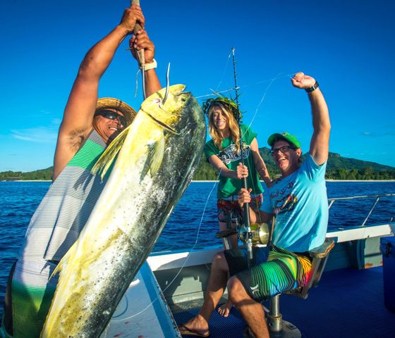 Three people on a boat with fish