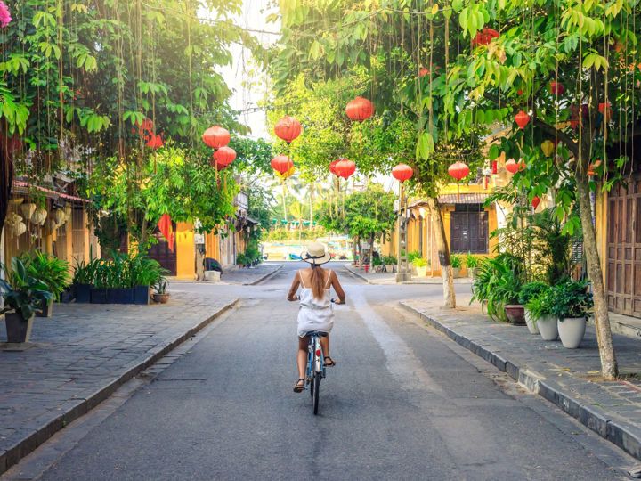 Woman riding biking through Hoi An streets