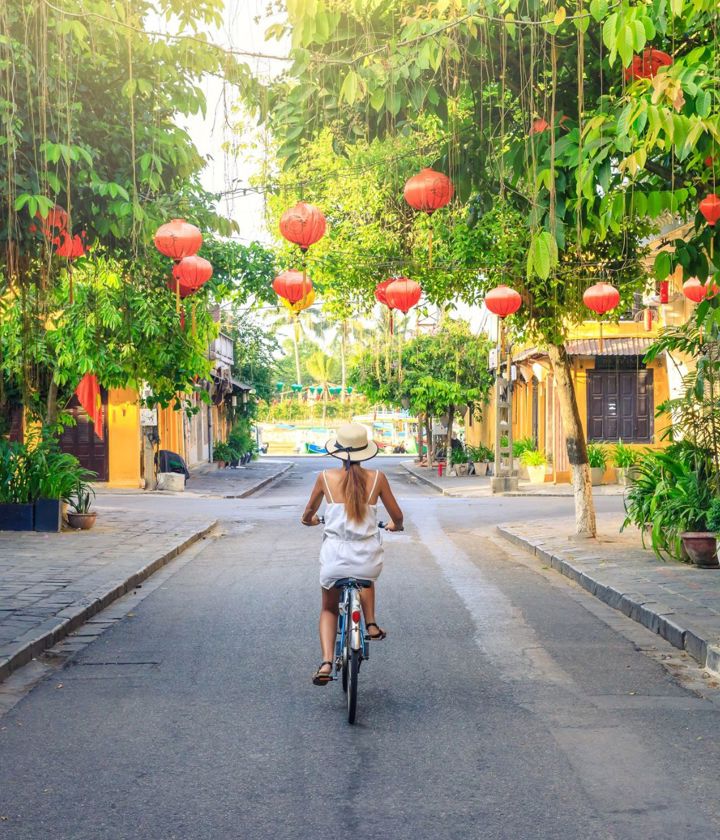 Woman riding biking through Hoi An streets