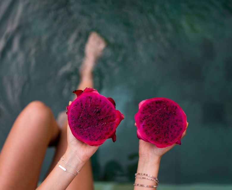 Person holding two pink fruits in canggu indonesia