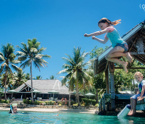 Girl jumping into ocean 